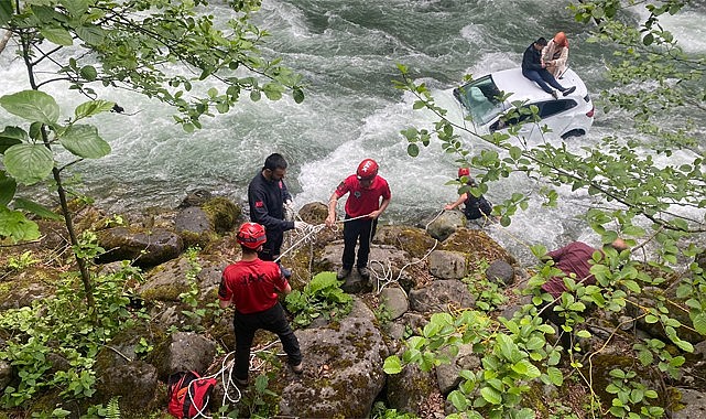 Genç çift dereye düşen otomobilin üzerine çıkarak kurtuldu